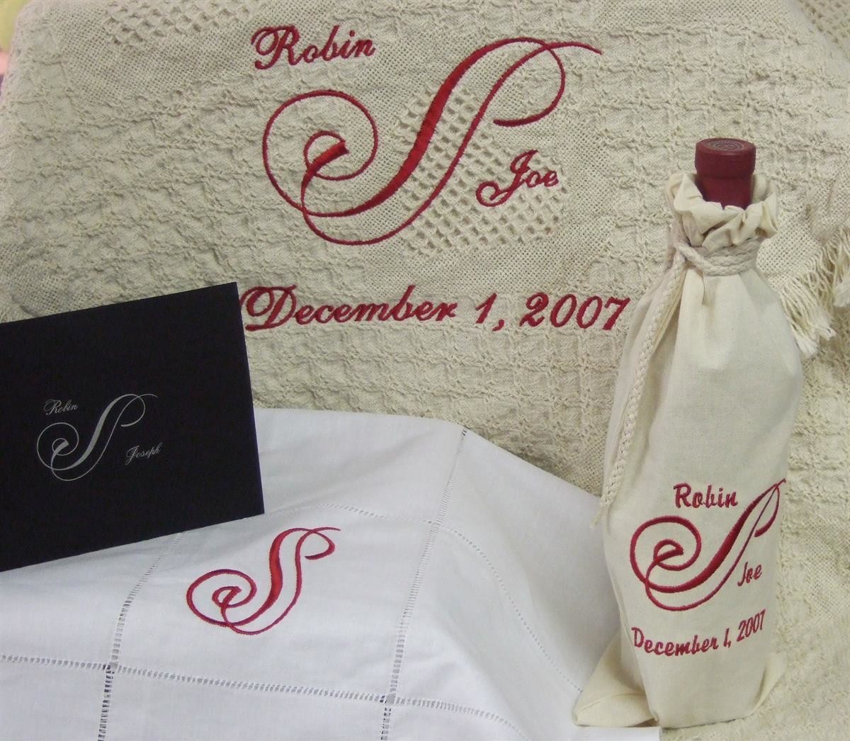 Wedding invitation in thread on table covering, wine bottle cover & blanket