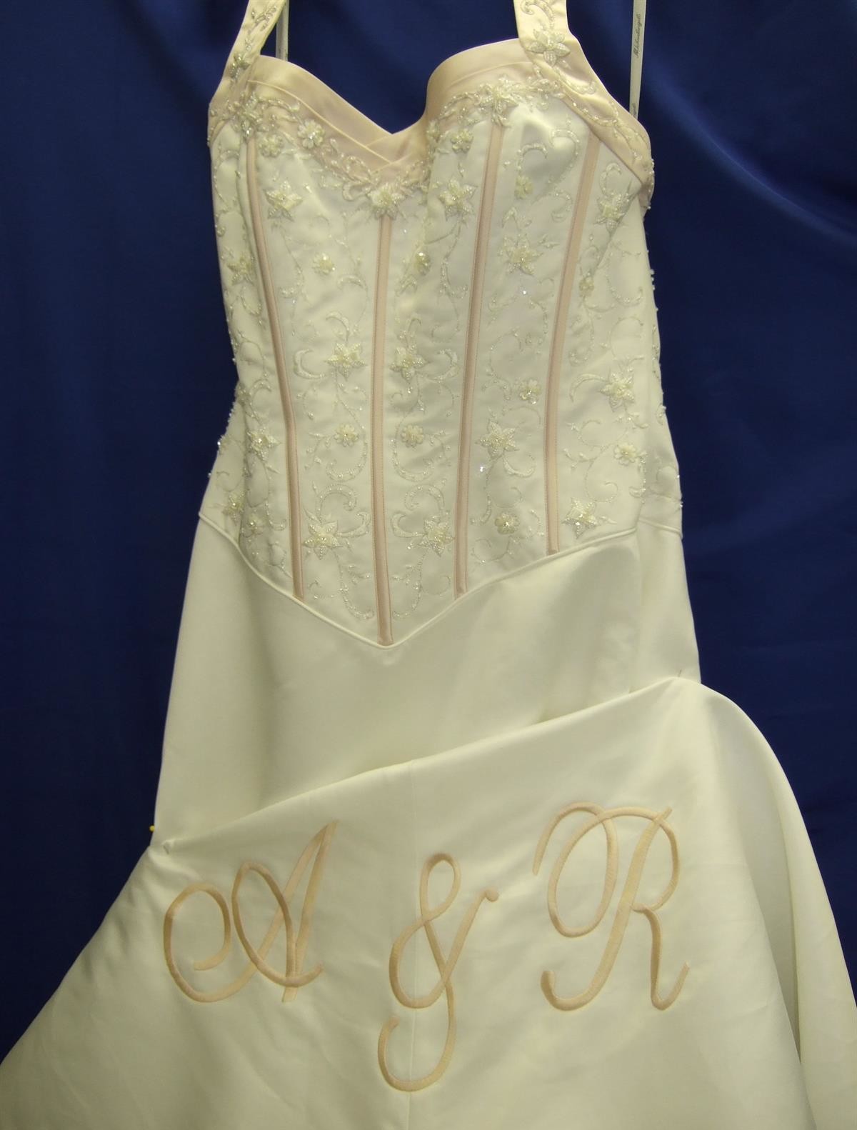 Bride and groom's monogram on train of wedding dress